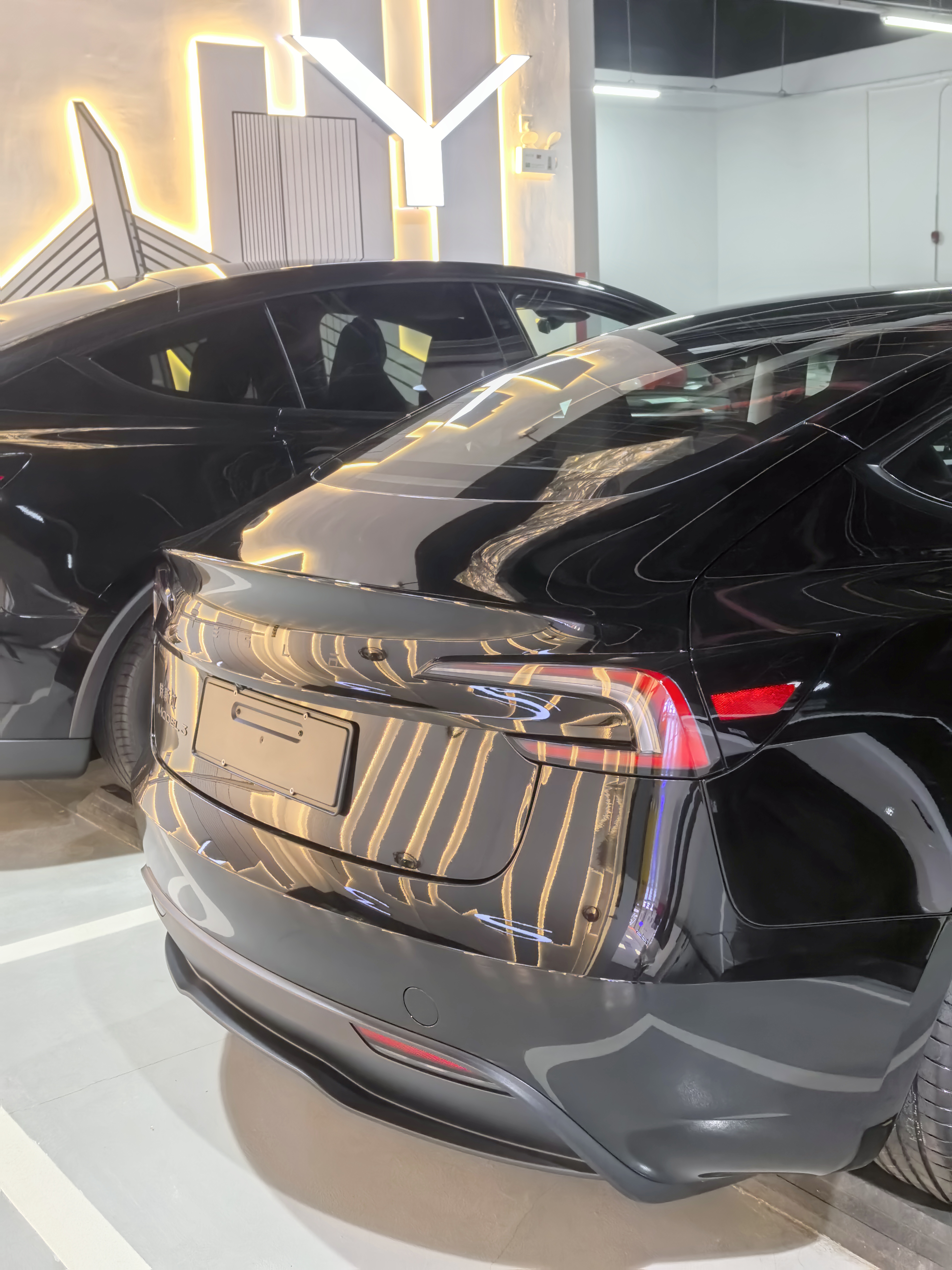 提车日记 | 穿lululemon提特斯拉🚗 这个新改版的特斯拉车标黑到看不出是什么车😞
不过新改几个讨喜：①前排座椅新增通风加热，后排加热
	
②前保险杠摄像头：新增了前保险杠摄像头，而且带清洗装置，这个是为了增强纯视觉体系，提升fsd能力用的，无法为旧款车改装
	
③微标颜色：前脸和尾部的Tesla标志从铬色（银色）改为全黑徽标，更低调且与无铬饰条设计更协调，但是黑色车漆黑标一点也看不出来，糊在一起了😞
	
④转向灯拨杆：恢复了传统的拨杆转向灯，原先焕新3取消了拨杆转向灯，采用按键转向灯，遭到了很多车主“唾弃”，当然也有部分车主认为按键转向灯更方便。
#特别心动的车 #人生第一辆小车车 #提车日记 #大玩具 #model3 #提车大吉 #提车 #交车仪式 #lululemon #所有的等待都是值得的 @丘丘-